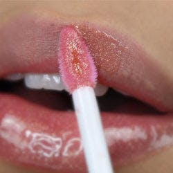 Application of vegan lip gloss in Glinda (Rose Gold Shimmer)